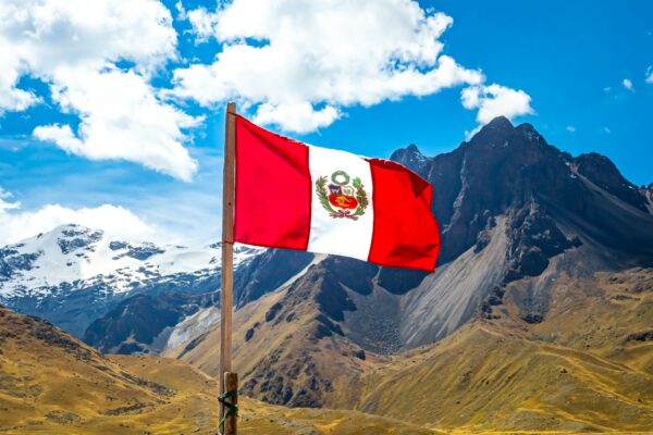 Peruvian flag against La Raya mountains, Peru